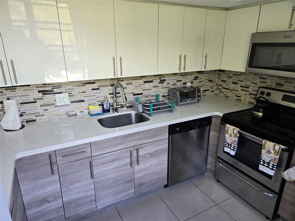 9400 Live Oak Place, Unit 305 Davie, FL 33324 - Photo 6 of 93 a kitchen with a stove and a microwave