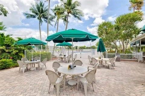 9400 Live Oak Place, Unit 305 Davie, FL 33324 - Photo 66 of 93 a patio with a patio table and chairs