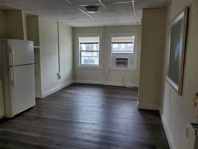 an empty room with wooden floor and a window
