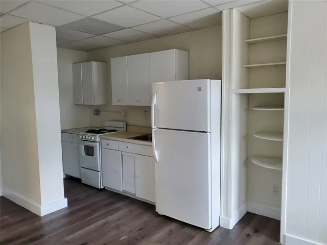 a white refrigerator freezer and a stove sitting inside of a kitchen