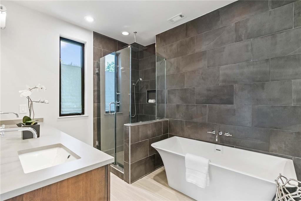 914 Lenox Boulevard Atlanta, GA 30324 - Photo 26 of 48 a bathroom with a tub sink and mirror