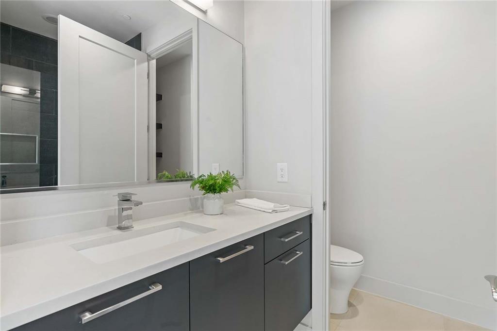 914 Lenox Boulevard Atlanta, GA 30324 - Photo 32 of 48 a bathroom with a granite countertop sink and a mirror with toilet