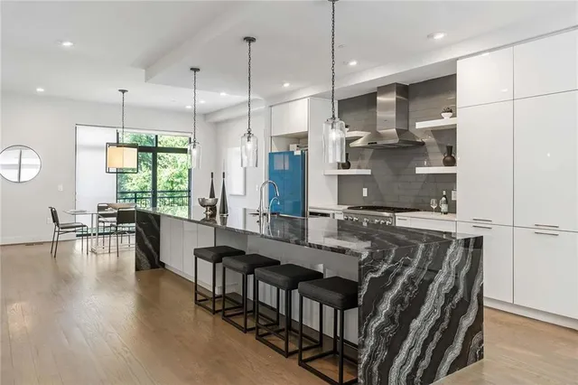 a kitchen with granite countertop a table chairs stove and cabinets
