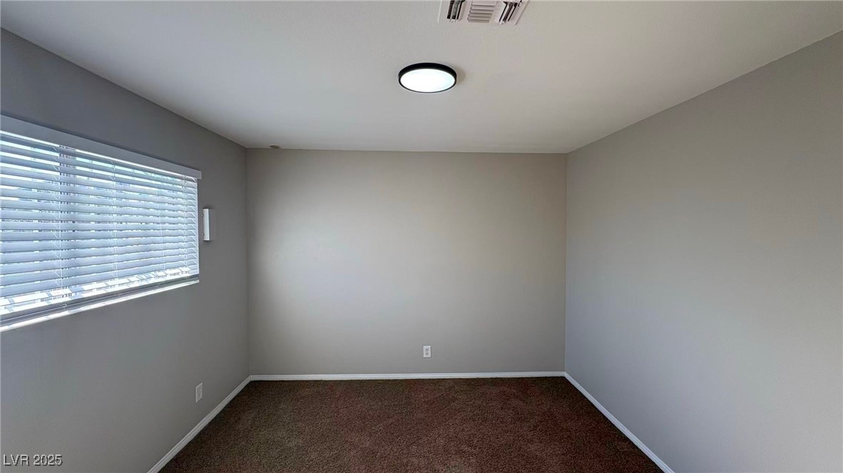 7113 Pinelake Road Las Vegas, NV 89145 - Photo 17 of 22 Empty room with dark carpet and baseboards