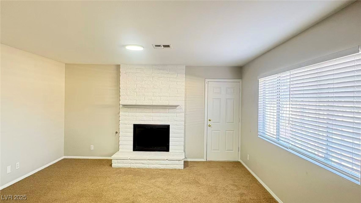 7113 Pinelake Road Las Vegas, NV 89145 - Photo 5 of 22 Unfurnished living room featuring carpet flooring and a fireplace