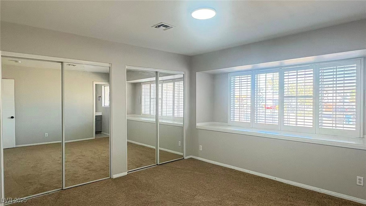 7113 Pinelake Road Las Vegas, NV 89145 - Photo 8 of 22 Unfurnished bedroom with two closets and carpet floors