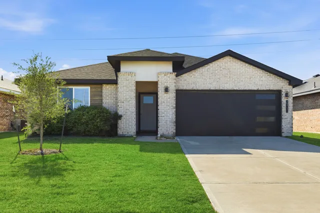 a front view of a house with a yard and garage