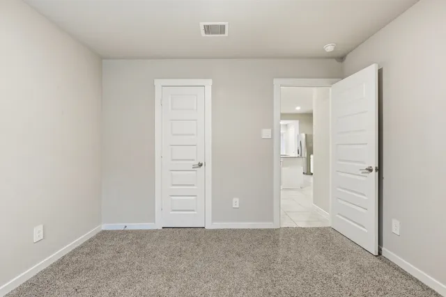 an empty room with closet and a bathroom
