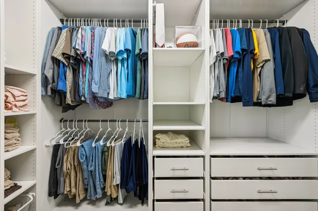 a view of walk in closet with clothes and shoes
