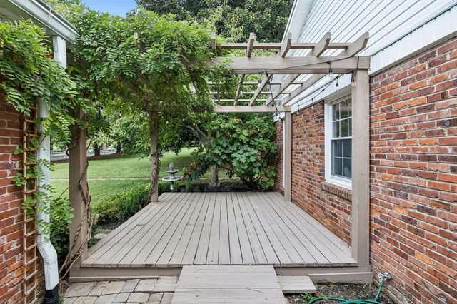 a view of a house with a yard and large tree