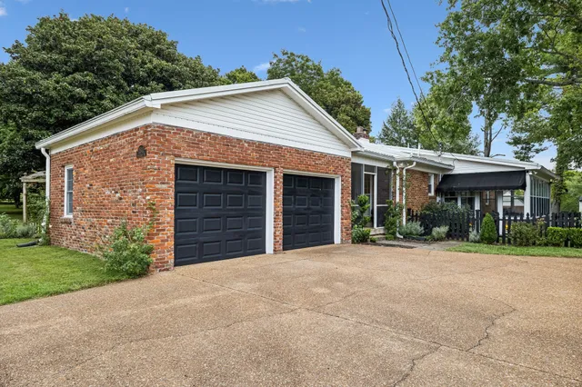 a front view of a house with a yard and potted plants
