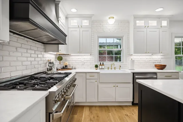 a kitchen with granite countertop a sink stove and cabinets