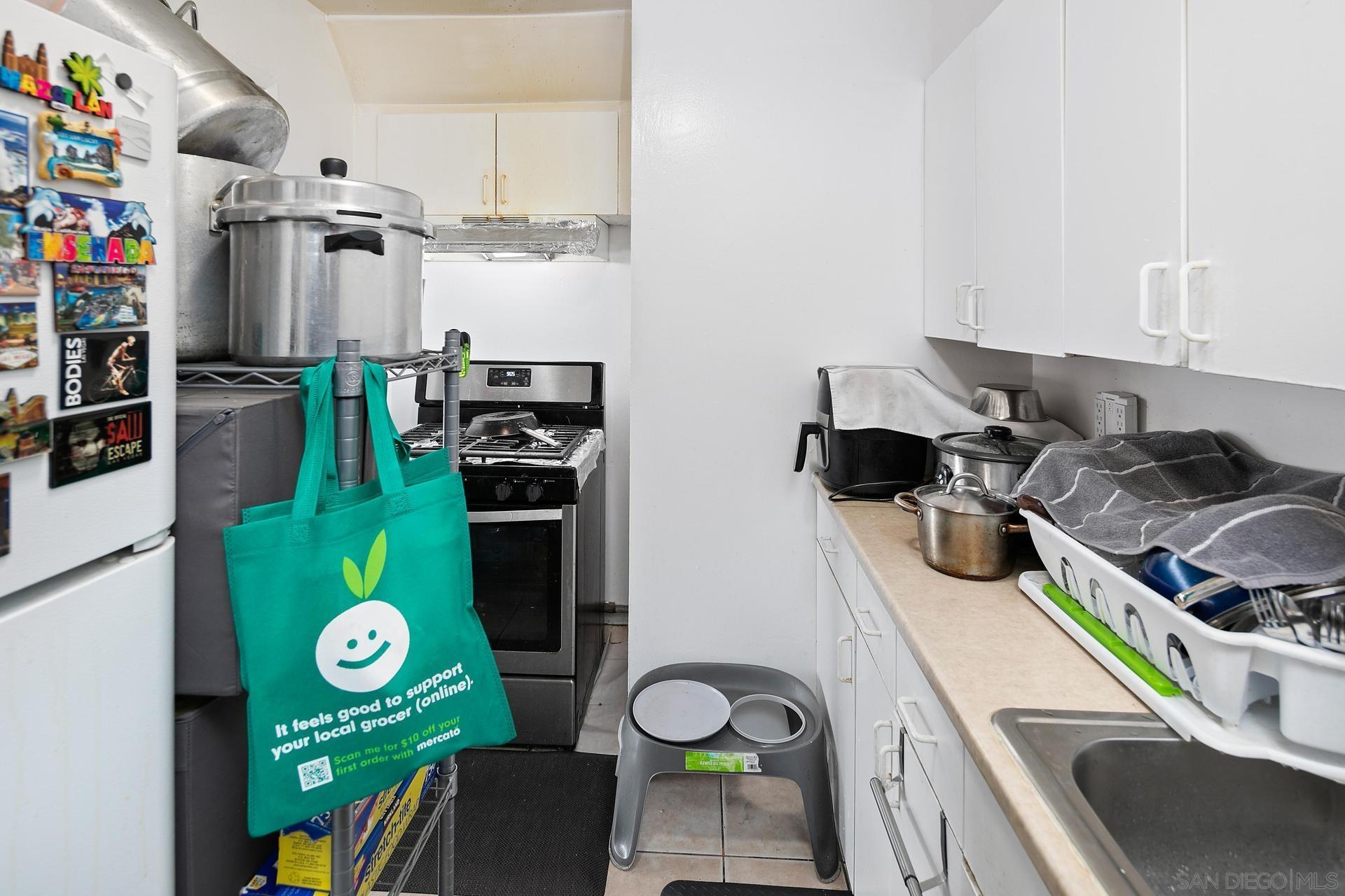 563 Madrona Street Chula Vista, CA 91910 - Photo 11 of 41 a kitchen with lots of clutter and stainless steel appliances