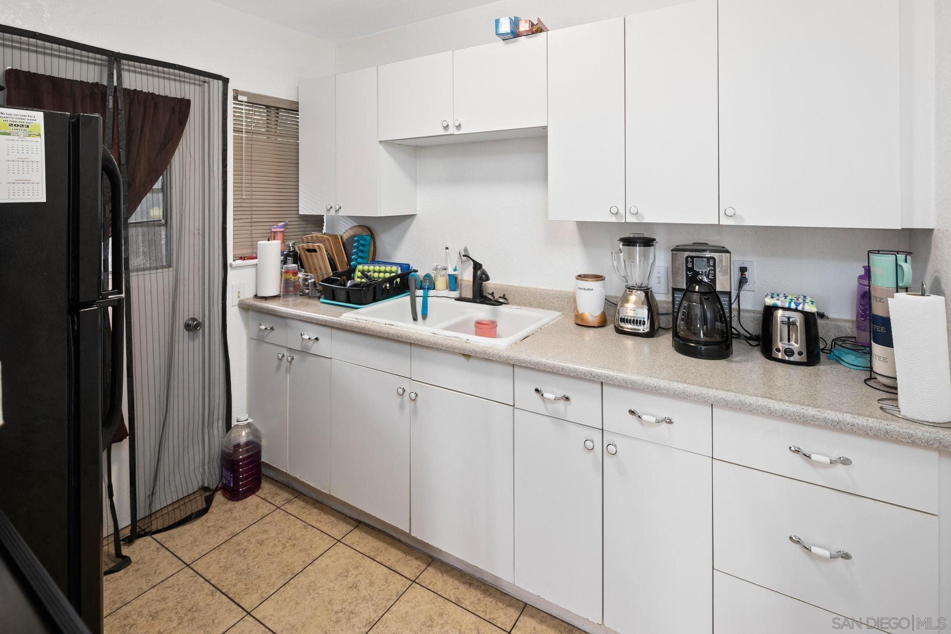 563 Madrona Street Chula Vista, CA 91910 - Photo 29 of 41 a kitchen with white cabinets and refrigerator