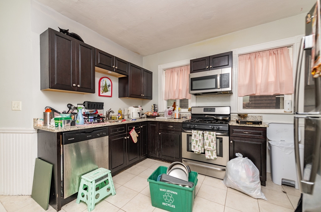 18 Santuit Street Boston, MA 02124 - Photo 16 of 17 a kitchen with stainless steel appliances granite countertop a stove top oven a sink dishwasher and cabinets