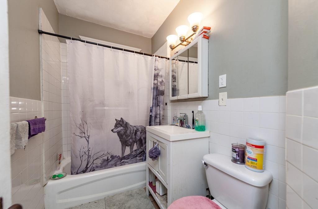 18 Santuit Street Boston, MA 02124 - Photo 10 of 17 a bathroom with a sink a toilet and shower curtain