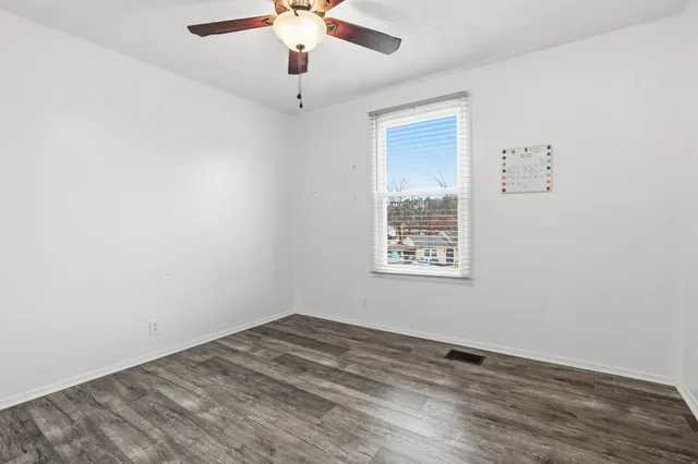 an empty room with a window and a ceiling fan