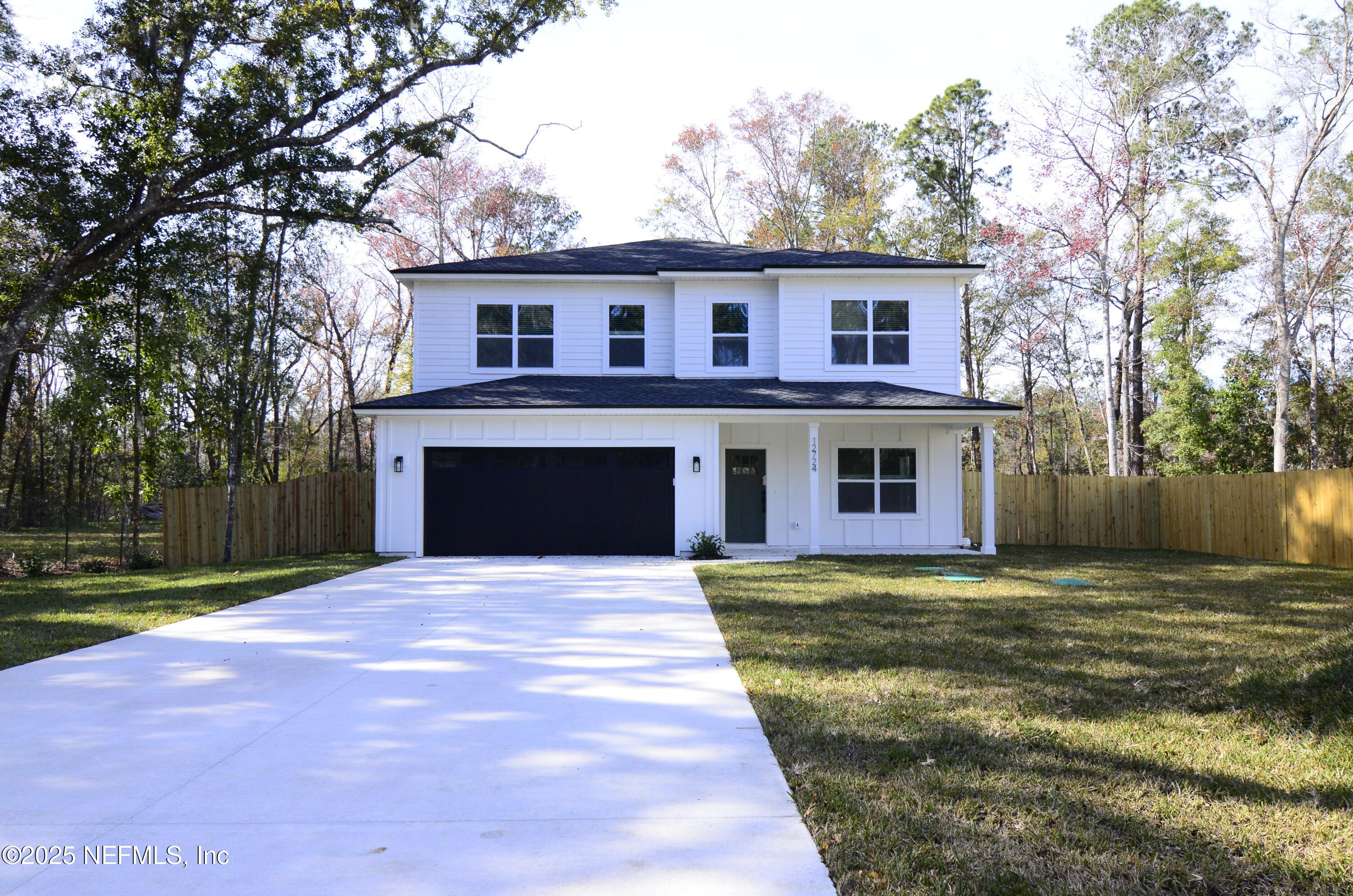 a front view of house with yard and trees in the background