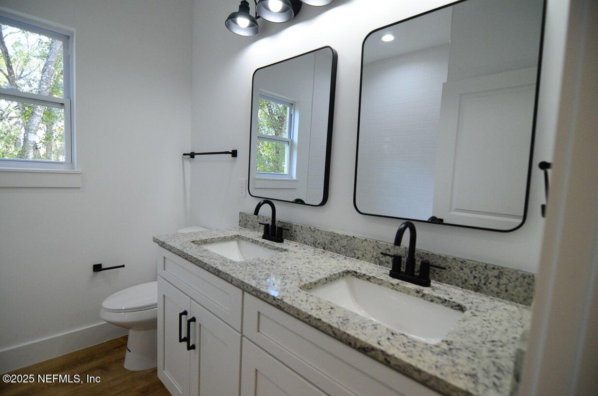 12724 Danbrook Street Jacksonville, FL 32223 - Photo 22 of 42 a bathroom with a granite countertop toilet sink and mirror
