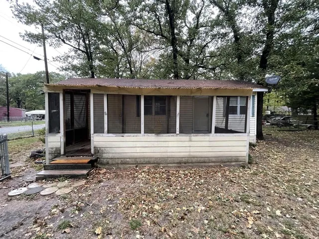 a view of a house with a yard and large tree