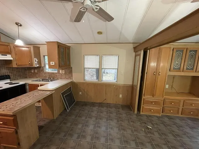 a kitchen with a stove a refrigerator and a sink