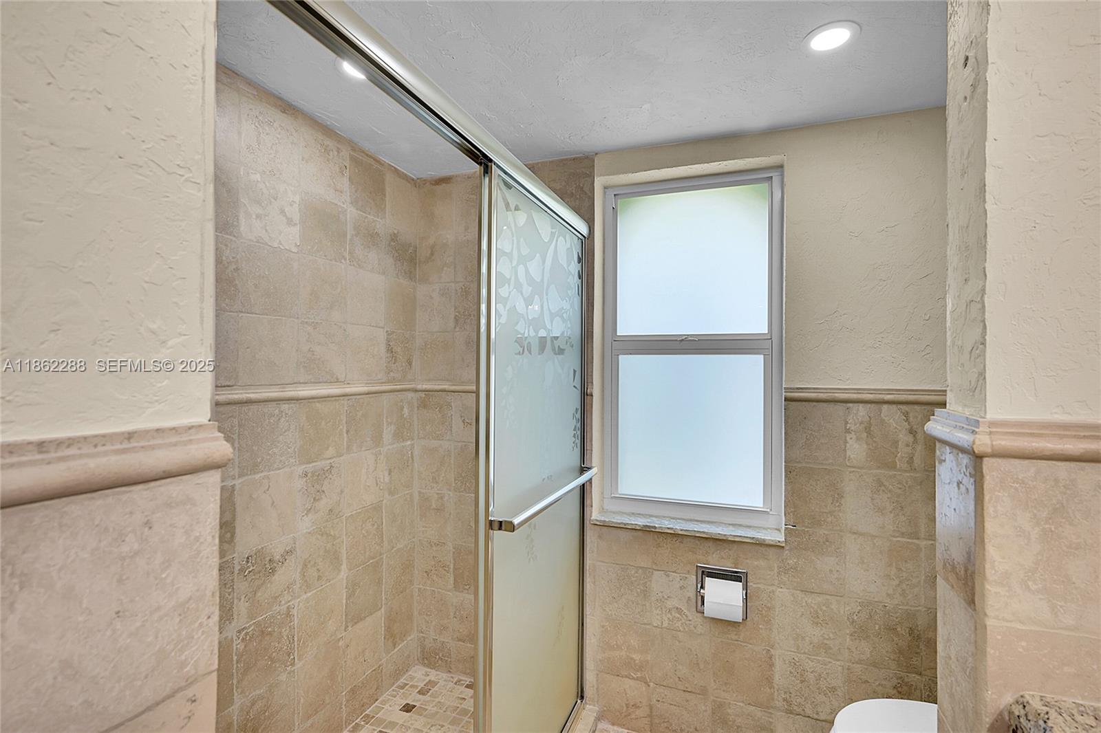 524 Muirfield Drive Atlantis, FL 33462 - Photo 22 of 55 a bathroom with a glass shower door