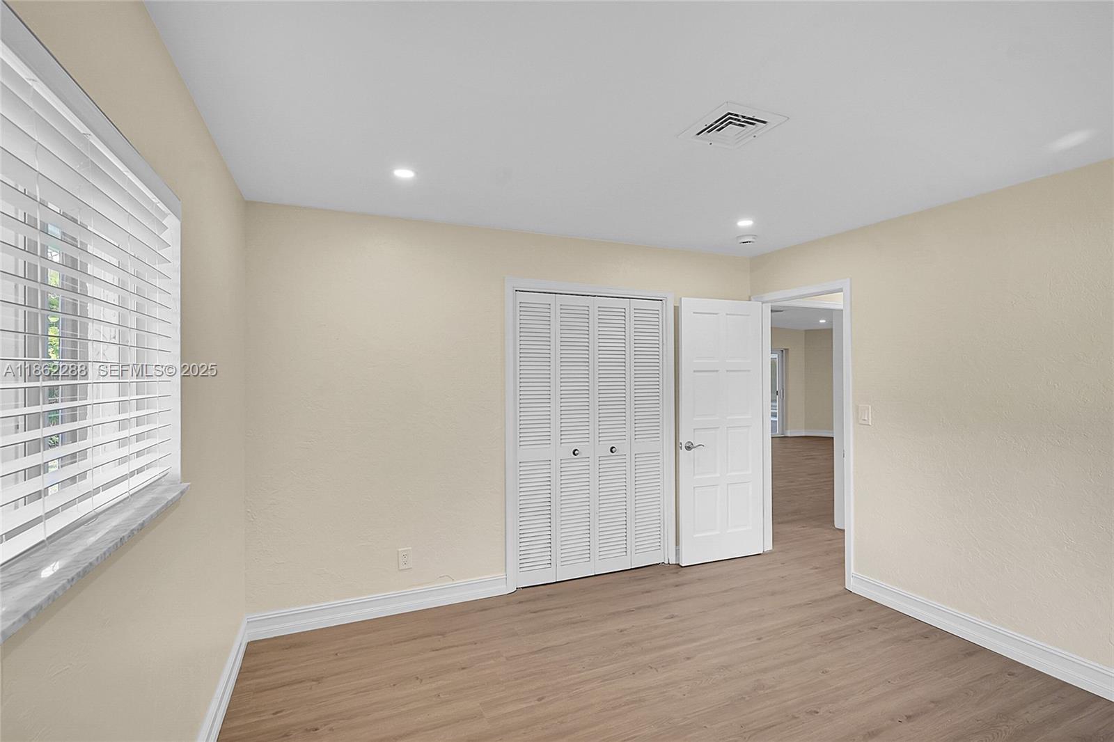 524 Muirfield Drive Atlantis, FL 33462 - Photo 24 of 55 a view of an empty room with wooden floor and a window