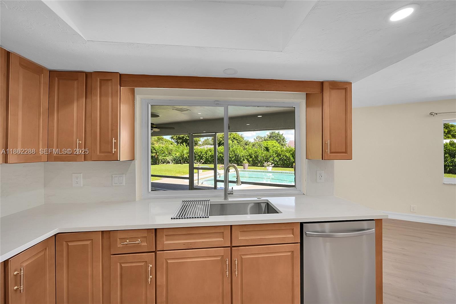 524 Muirfield Drive Atlantis, FL 33462 - Photo 26 of 55 a kitchen with stainless steel appliances granite countertop a sink a window and a counter space