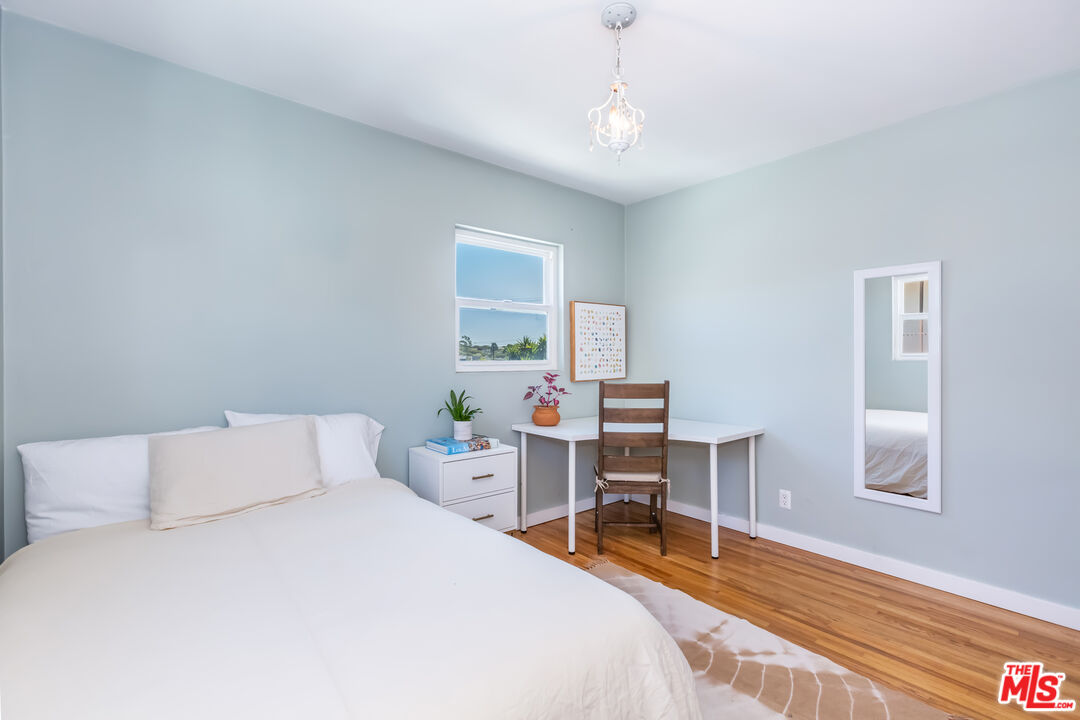 1835 7th Street, Unit D Santa Monica, CA 90401 - Photo 8 of 9 a bedroom with a bed a table and chair