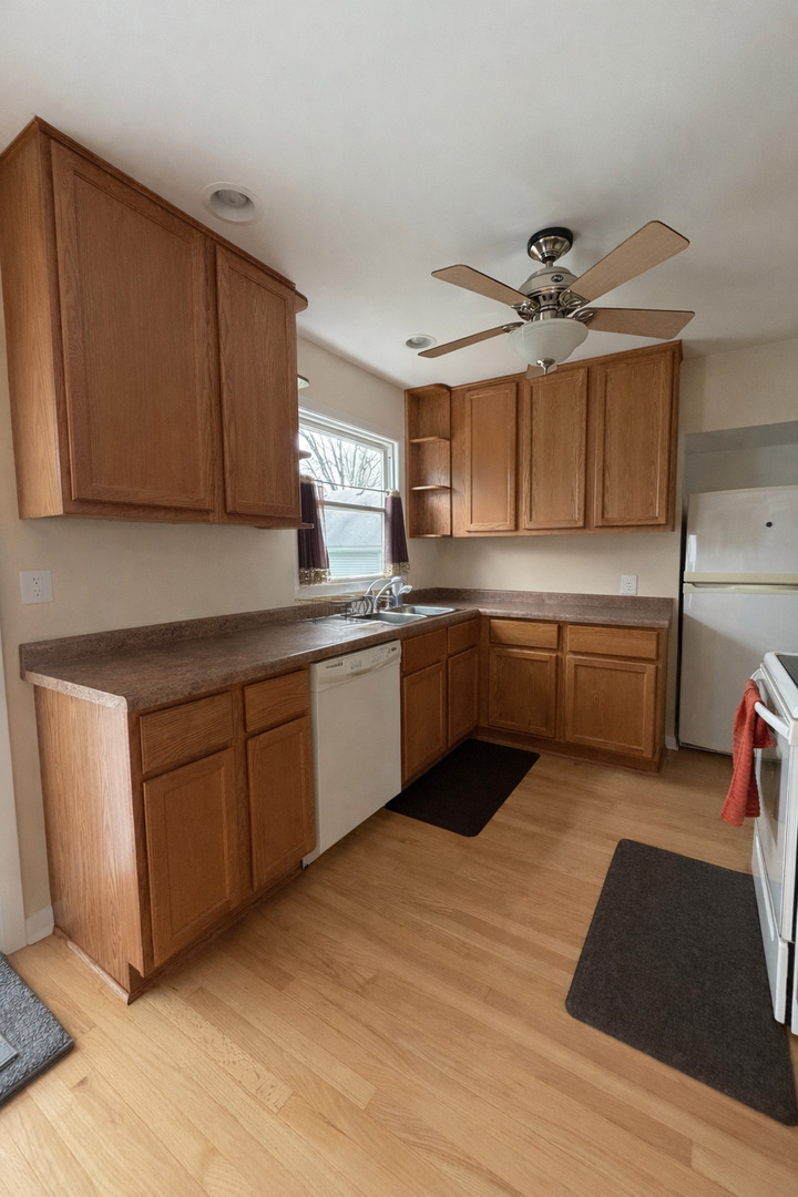 3935 Arthur Terrace Court Markham, IL 60428 - Photo 6 of 22 a kitchen with stainless steel appliances granite countertop a sink dishwasher stove and cabinets with wooden floor