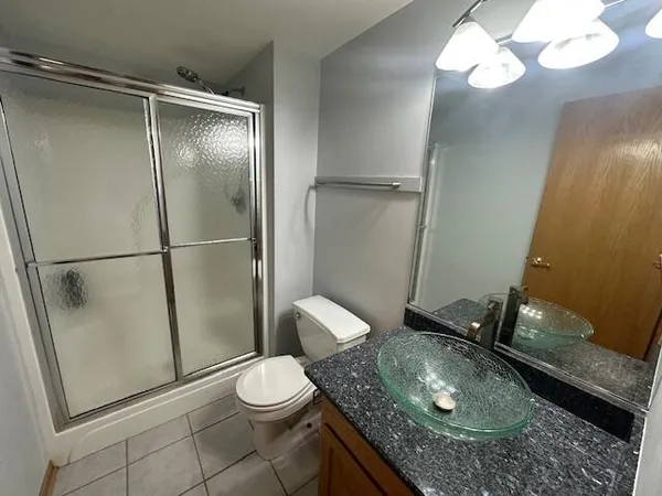 a bathroom with a granite countertop sink toilet and shower