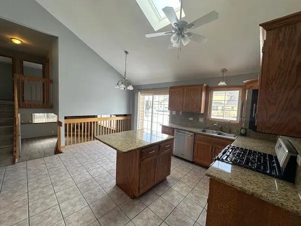 a kitchen with stainless steel appliances granite countertop a stove a sink and a refrigerator