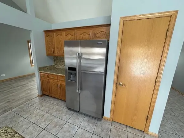 a room with a refrigerator and cabinets