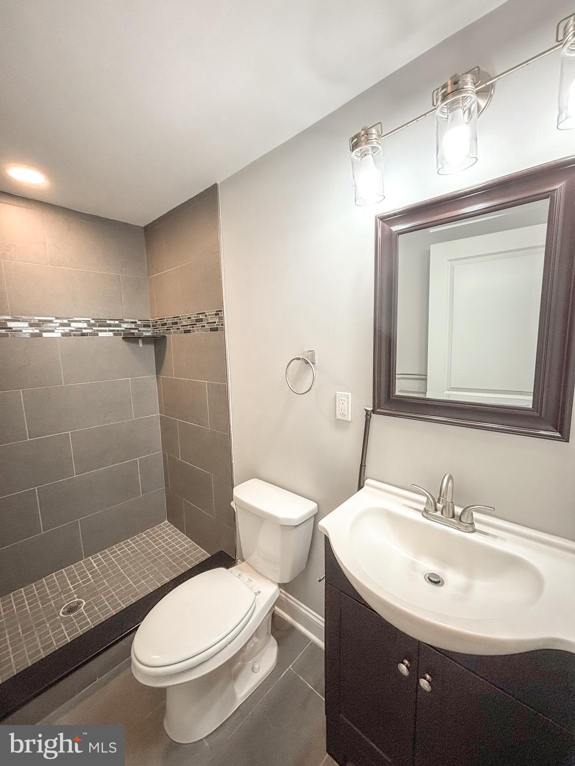 1526 South Cleveland Street Philadelphia, PA 19146 - Photo 27 of 30 a bathroom with a toilet a sink a mirror and a shower