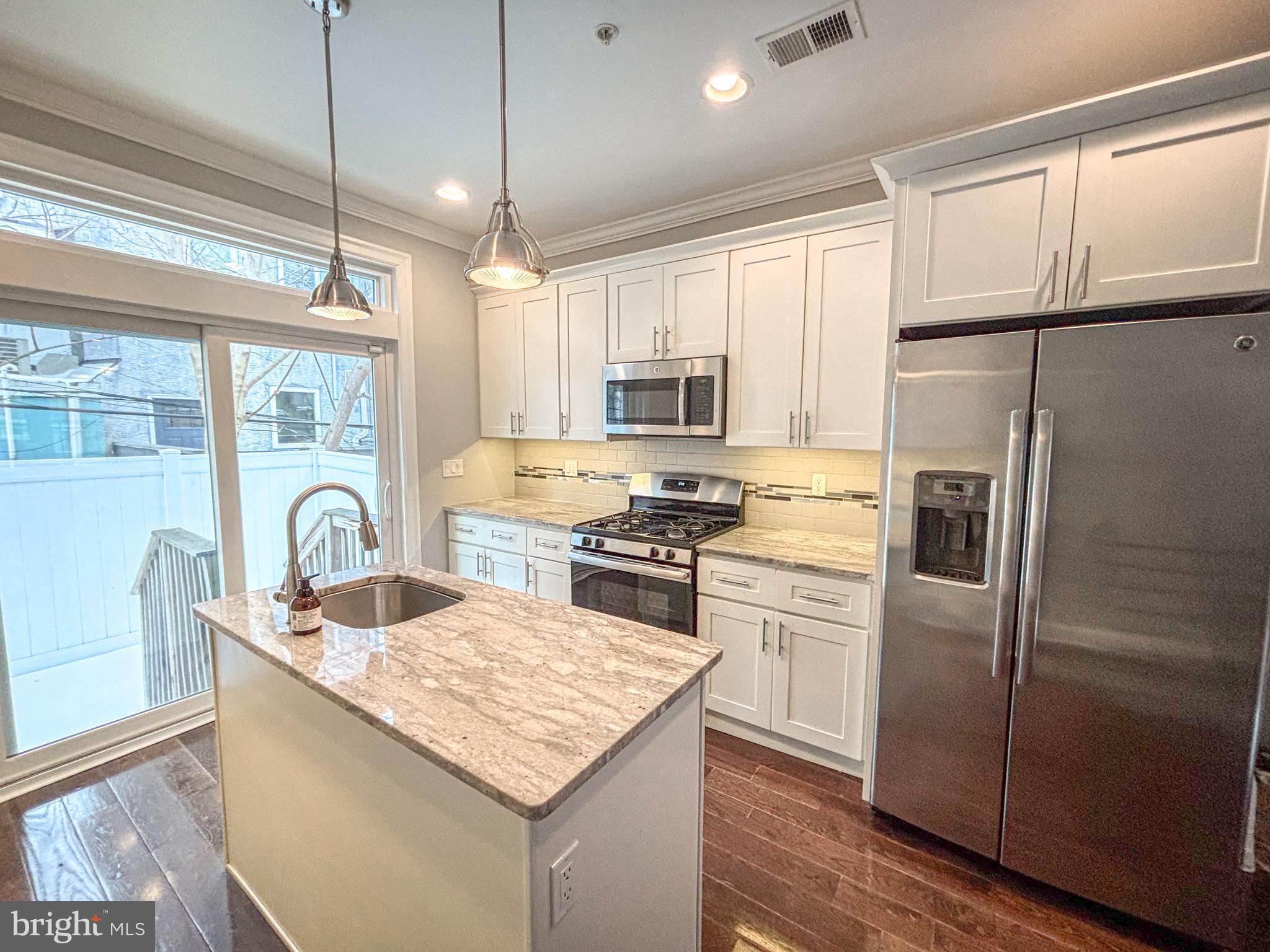 1526 South Cleveland Street Philadelphia, PA 19146 - Photo 8 of 30 a kitchen with kitchen island a counter space a sink appliances and cabinets