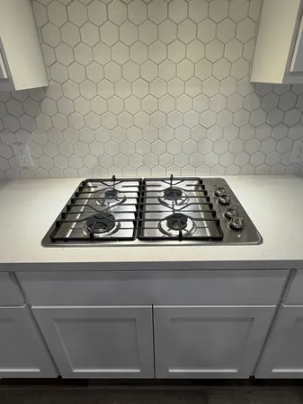 a kitchen with wooden floors and white cabinets