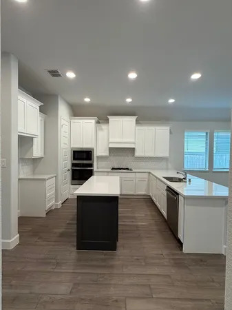 a kitchen with a sink microwave and cabinets