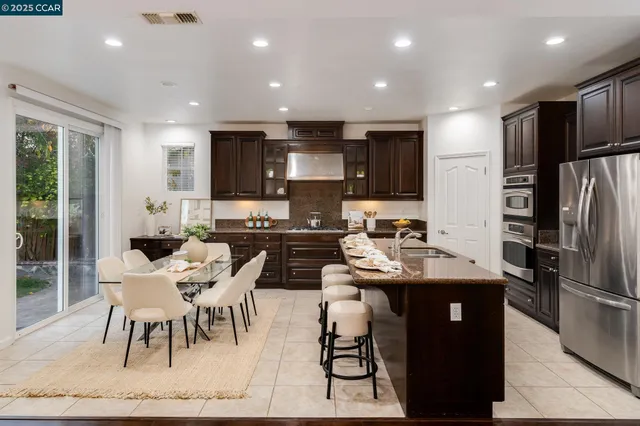 a kitchen with stainless steel appliances kitchen island granite countertop a sink and cabinets