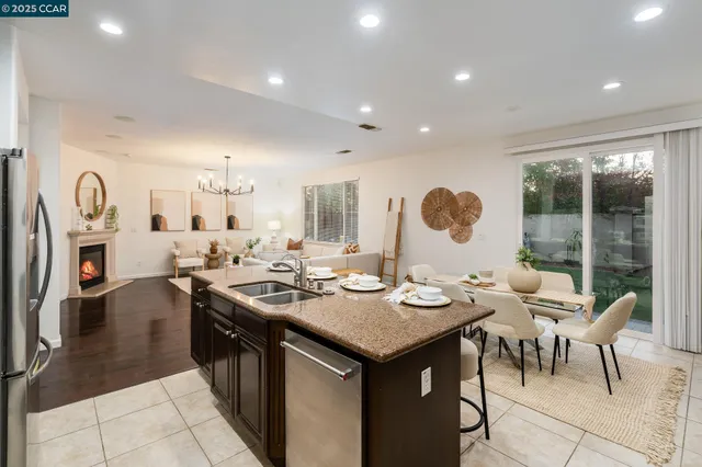 a dining hall with stainless steel appliances granite countertop a stove and a sink