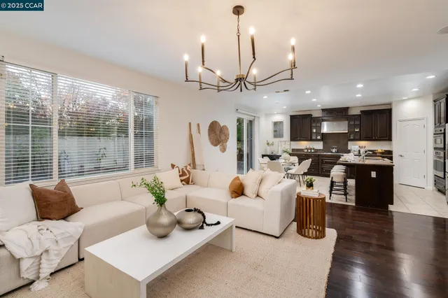 a living room with furniture kitchen area and a large window