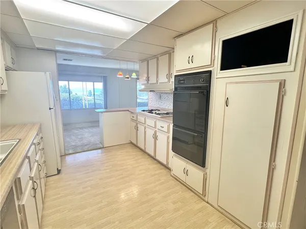 a view of a kitchen with a stove fridge and wooden floor