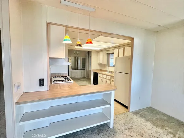 a view of kitchen with furniture and refrigerator
