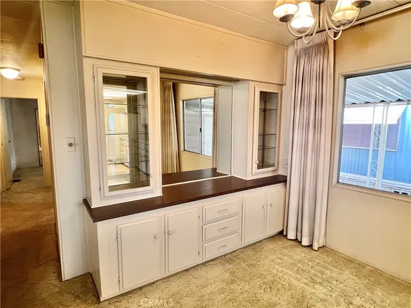 a large white kitchen with granite countertop a sink and dishwasher with wooden floor