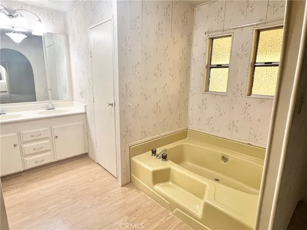 a bathroom with a tub sink and mirror
