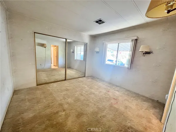 an empty room with windows and closet