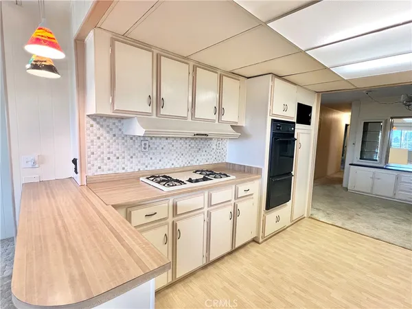 a kitchen with stainless steel appliances granite countertop a stove a refrigerator and a white cabinets