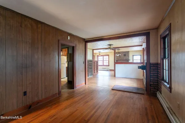 a view of a hallway with wooden floor windows