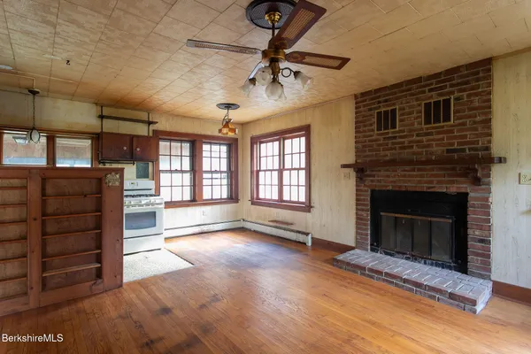 a view of an empty room with a fireplace and a window