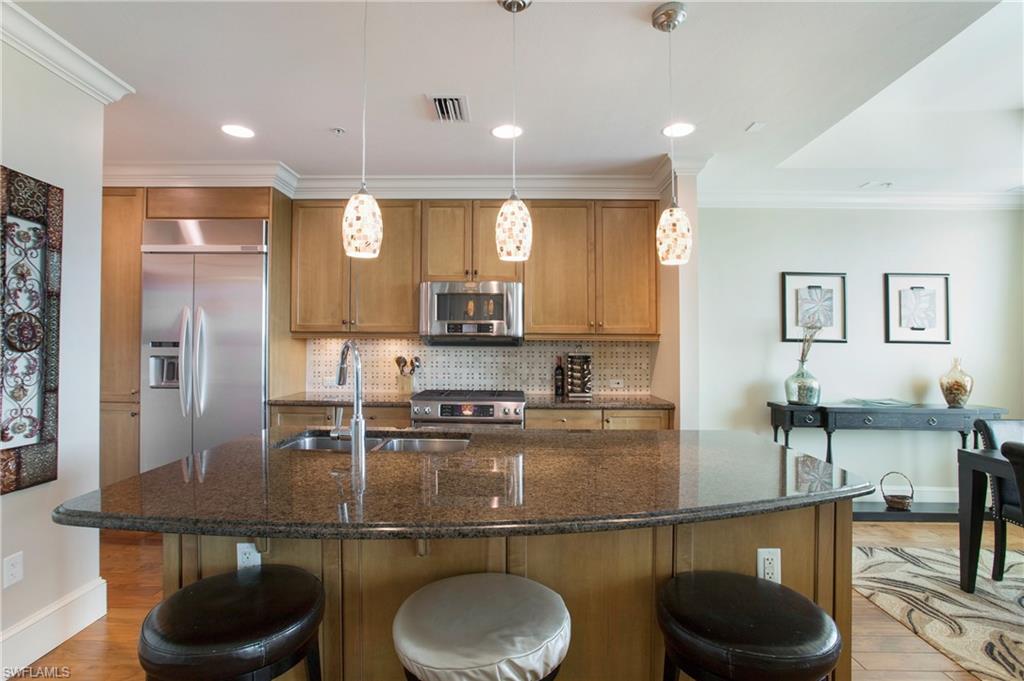 9123 Strada Place, Unit 7307 Naples, FL 34108 - Photo 11 of 49 a kitchen with stainless steel appliances granite countertop a sink and a refrigerator
