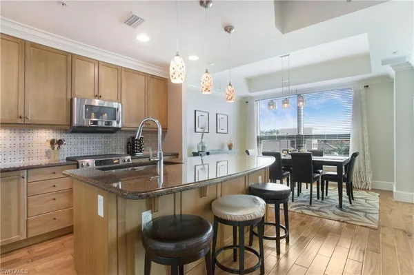 a kitchen with stainless steel appliances granite countertop a stove a sink and a microwave